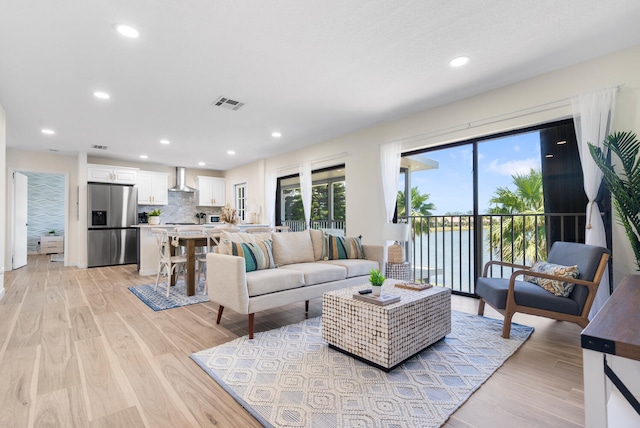 living room featuring a water view and light wood-type flooring