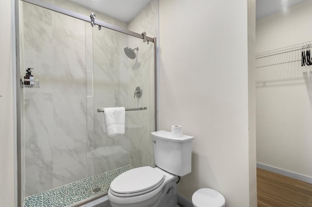 bathroom featuring hardwood / wood-style flooring, toilet, and walk in shower