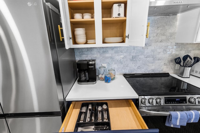 kitchen with wood counters, stainless steel appliances, extractor fan, and tasteful backsplash