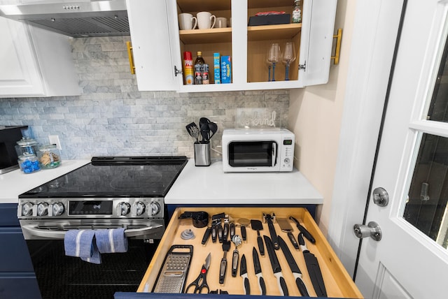 kitchen with decorative backsplash, electric stove, white cabinetry, and wall chimney exhaust hood