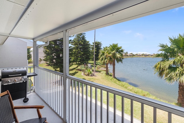 sunroom featuring a water view