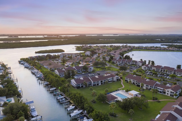 aerial view at dusk featuring a water view