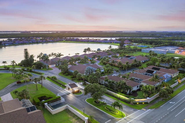 aerial view at dusk featuring a water view