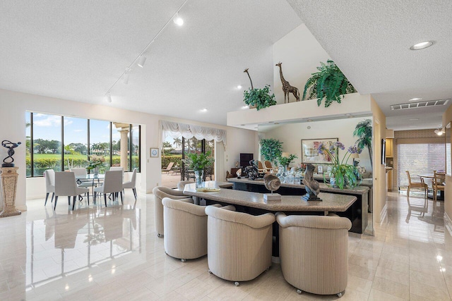 living room featuring rail lighting, light tile patterned flooring, and a textured ceiling