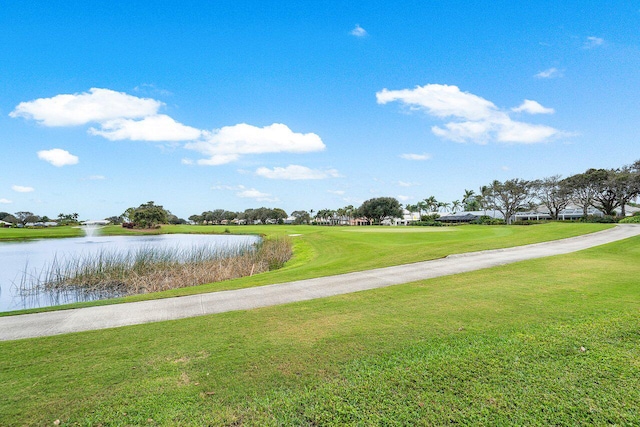 surrounding community with a water view and a lawn