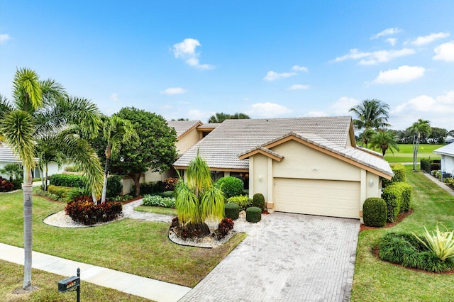 ranch-style home featuring a garage and a front lawn