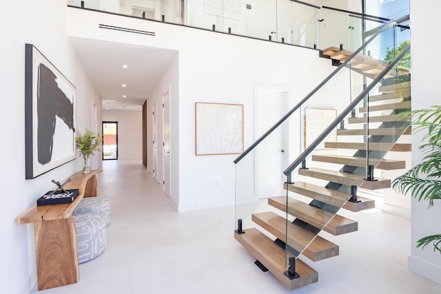 stairway featuring a high ceiling