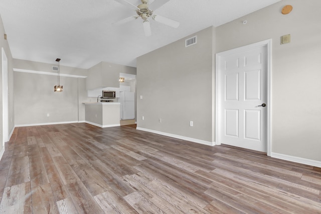 unfurnished living room with ceiling fan and light hardwood / wood-style flooring