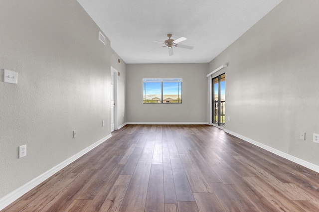 empty room with a textured ceiling, ceiling fan, and dark hardwood / wood-style flooring