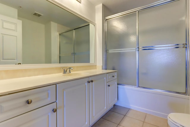 full bathroom featuring tile patterned floors, enclosed tub / shower combo, vanity, and toilet