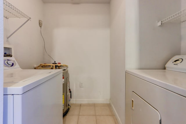 laundry room featuring light tile patterned floors, water heater, and washer and dryer