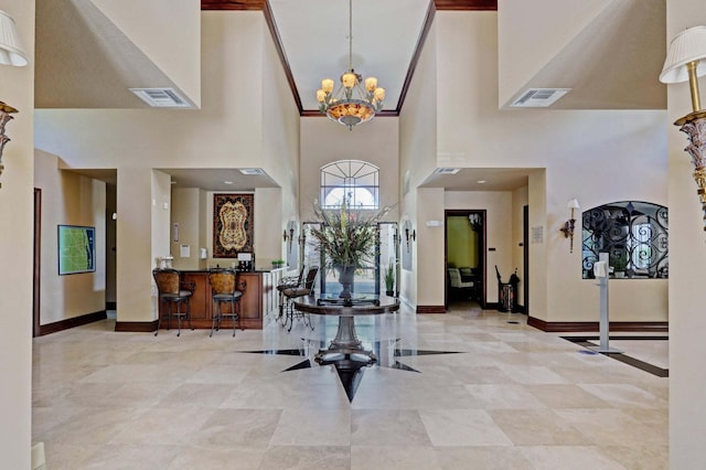 foyer entrance featuring a towering ceiling and an inviting chandelier