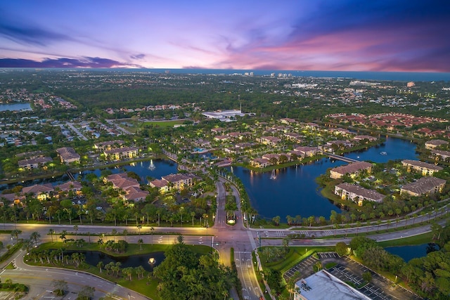 aerial view at dusk featuring a water view