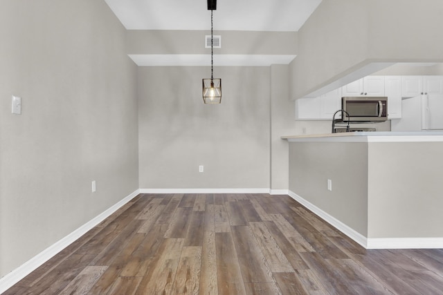 unfurnished dining area featuring dark hardwood / wood-style flooring