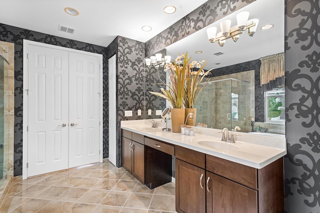 bathroom with a shower with shower door, vanity, and tile patterned flooring