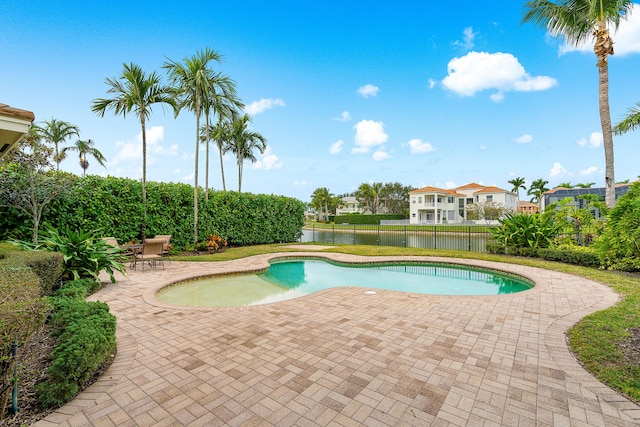 view of pool featuring a water view and a patio