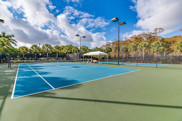 view of tennis court featuring basketball hoop