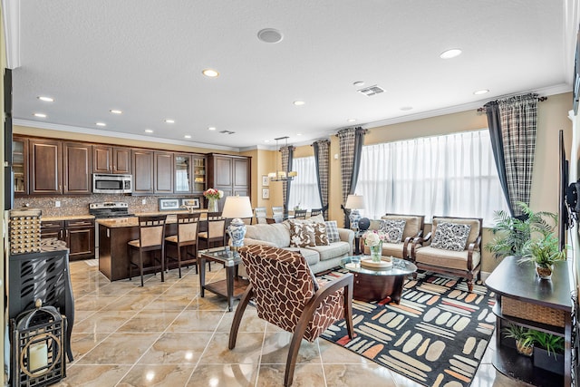 living room featuring an inviting chandelier, light tile patterned floors, and crown molding