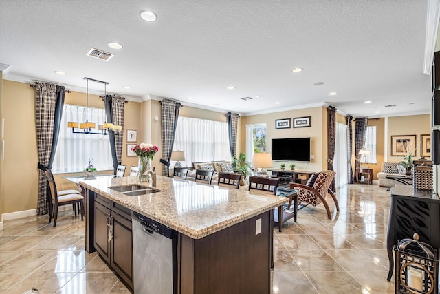 kitchen featuring light stone countertops, dark brown cabinetry, dishwasher, sink, and a center island with sink