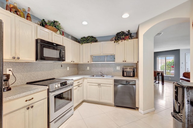 kitchen with black appliances, light tile patterned floors, and backsplash