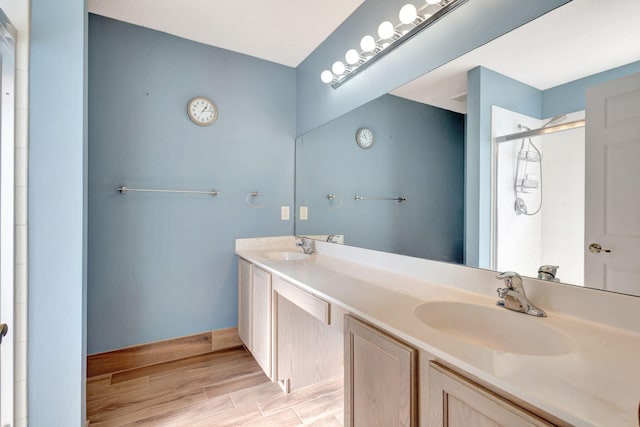 bathroom featuring a shower with shower door and vanity