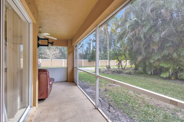 unfurnished sunroom featuring ceiling fan