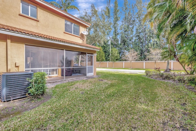 view of yard featuring a sunroom and central air condition unit