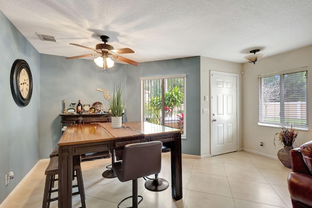 tiled dining area featuring ceiling fan