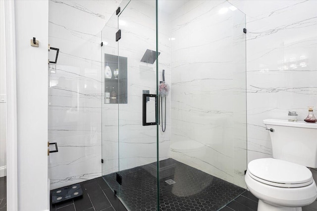 bathroom with tile patterned flooring, a shower with shower door, and toilet