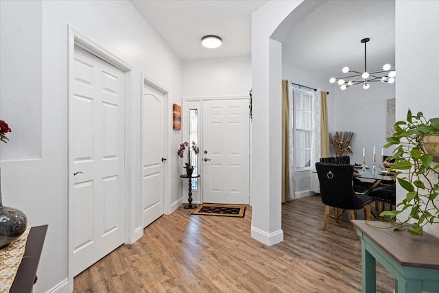 foyer entrance with an inviting chandelier and light wood-type flooring