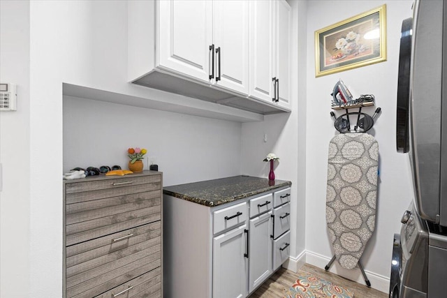 kitchen featuring dark stone countertops and white cabinets