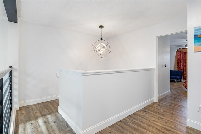 hallway featuring wood-type flooring and a chandelier