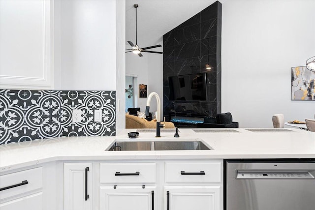 kitchen with sink, ceiling fan, white cabinetry, decorative backsplash, and stainless steel dishwasher