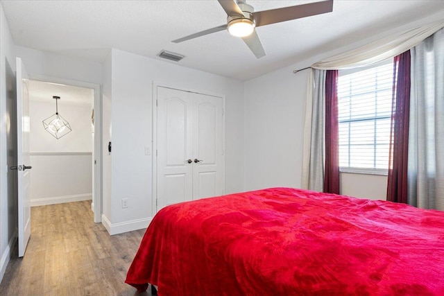 bedroom featuring ceiling fan, wood-type flooring, and a closet