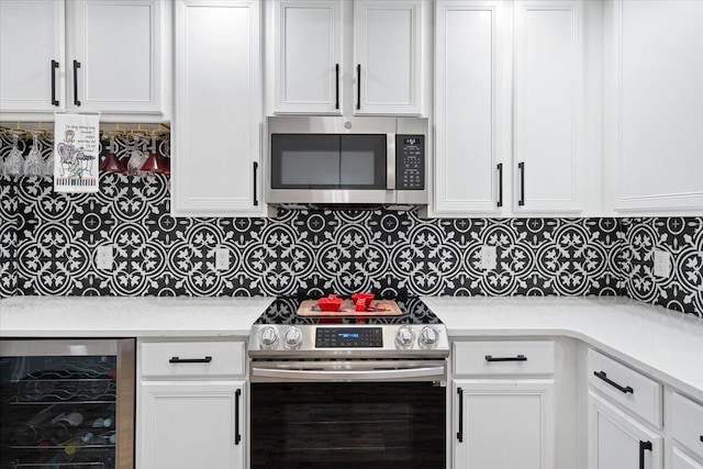 kitchen featuring wine cooler, white cabinetry, and appliances with stainless steel finishes