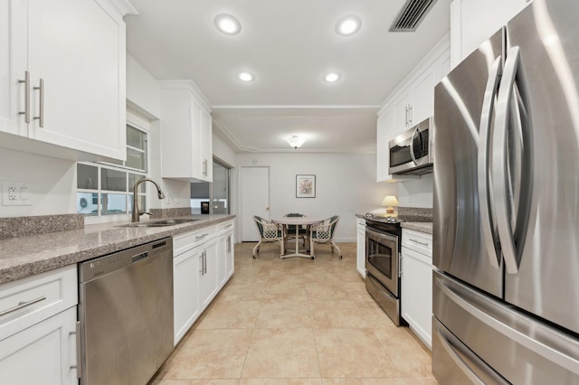 kitchen with light stone counters, sink, white cabinetry, and appliances with stainless steel finishes