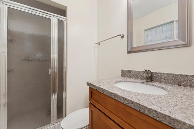 bathroom with a shower with door, toilet, and vanity