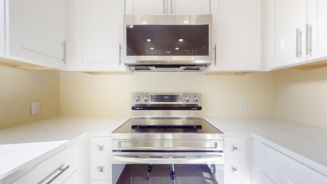 kitchen featuring light stone counters, white cabinetry, and appliances with stainless steel finishes