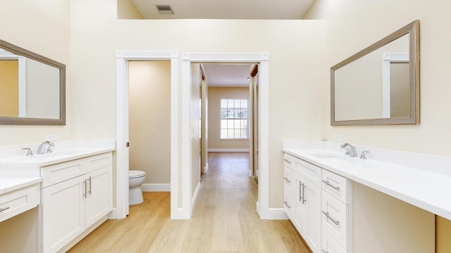 bathroom featuring toilet, hardwood / wood-style flooring, and vanity