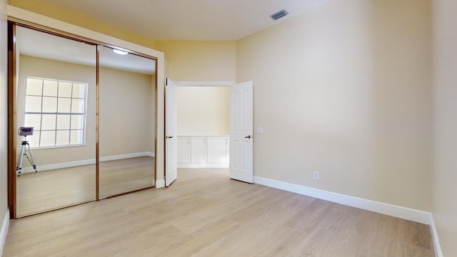 unfurnished bedroom with a closet and light hardwood / wood-style floors