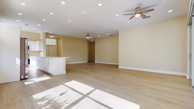 unfurnished living room with ceiling fan and light hardwood / wood-style flooring