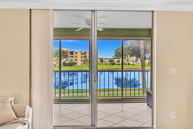 doorway featuring ceiling fan, a water view, light tile patterned flooring, and ornamental molding