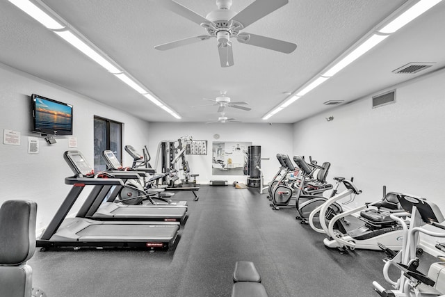 gym with ceiling fan and a textured ceiling