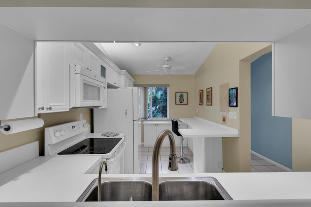 kitchen with light tile patterned floors, white cabinetry, ceiling fan, white appliances, and sink