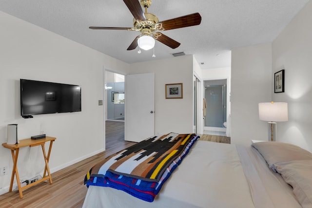 bedroom featuring a textured ceiling, ceiling fan, connected bathroom, and wood-type flooring