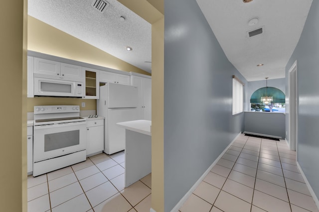 kitchen with light tile patterned floors, white cabinetry, decorative light fixtures, white appliances, and lofted ceiling