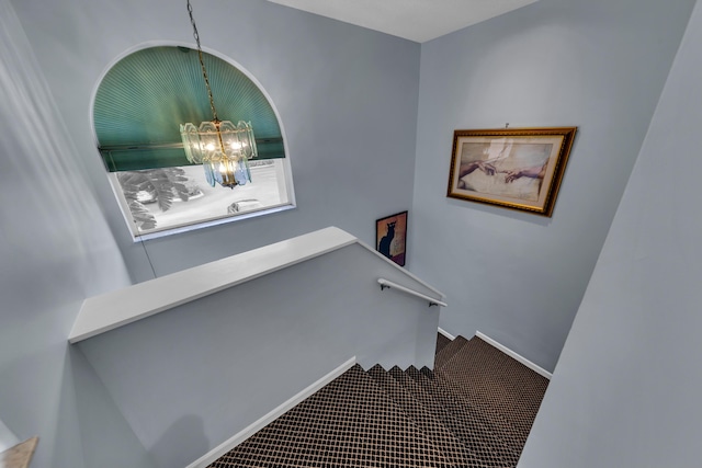 staircase featuring a chandelier