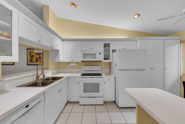 kitchen with white cabinetry, sink, white appliances, and lofted ceiling