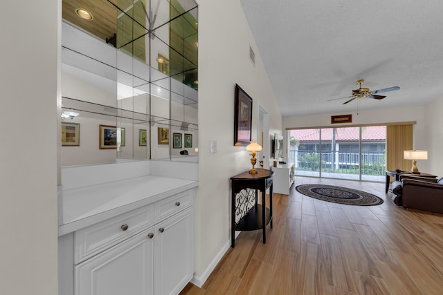 corridor featuring lofted ceiling and a textured ceiling