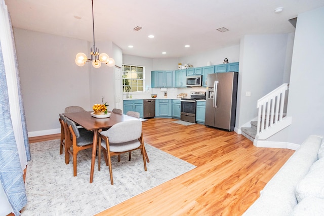 dining area featuring a notable chandelier, light hardwood / wood-style flooring, and sink